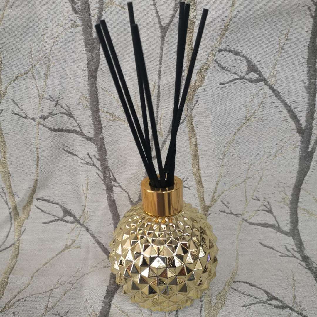 Gold textured diffuser bottle with black sticks 